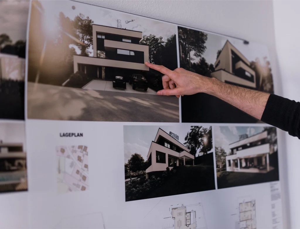 Architekturpläne mit einer Hand, die darauf zeigt.