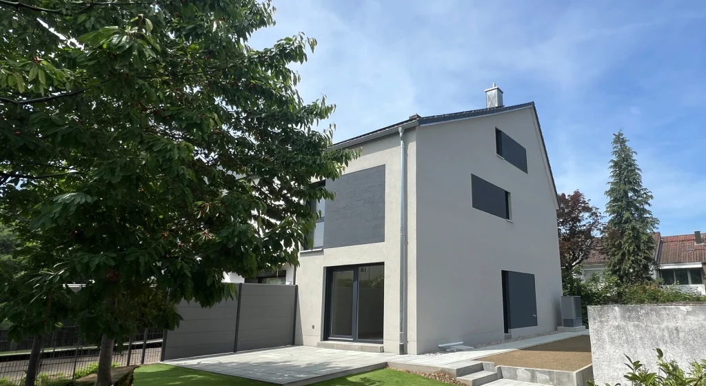 Massivhaus auf einem gepflegten Grundstück mit Rasen und Bäumen