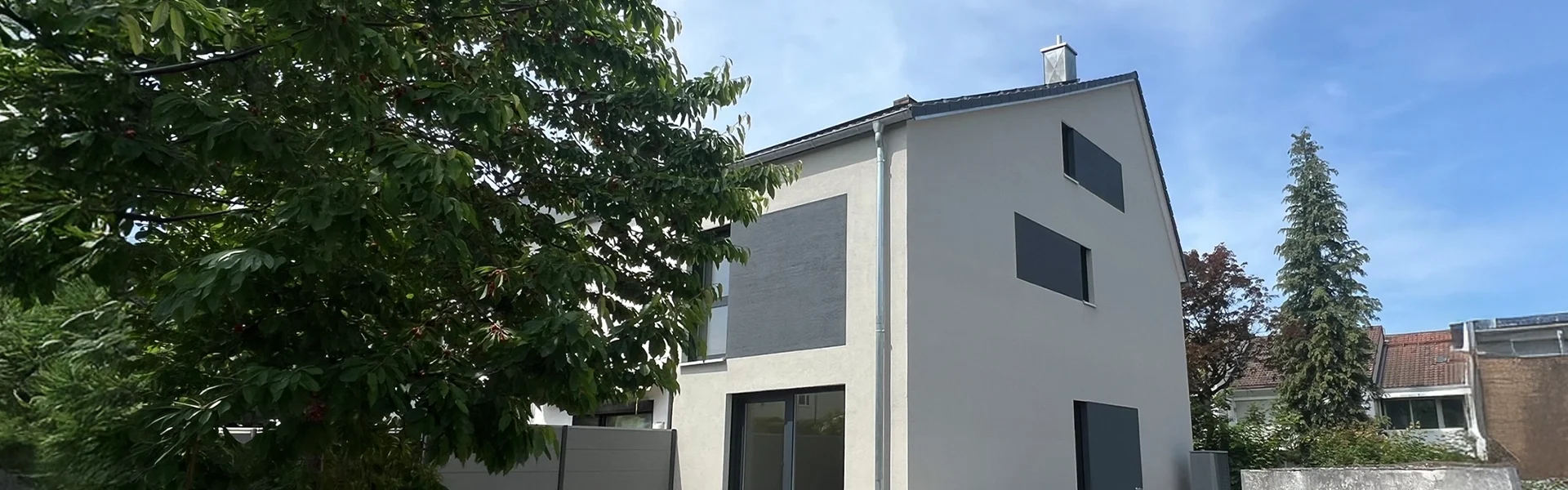 Massivhaus auf einem gepflegten Grundstück mit Rasen und Bäumen