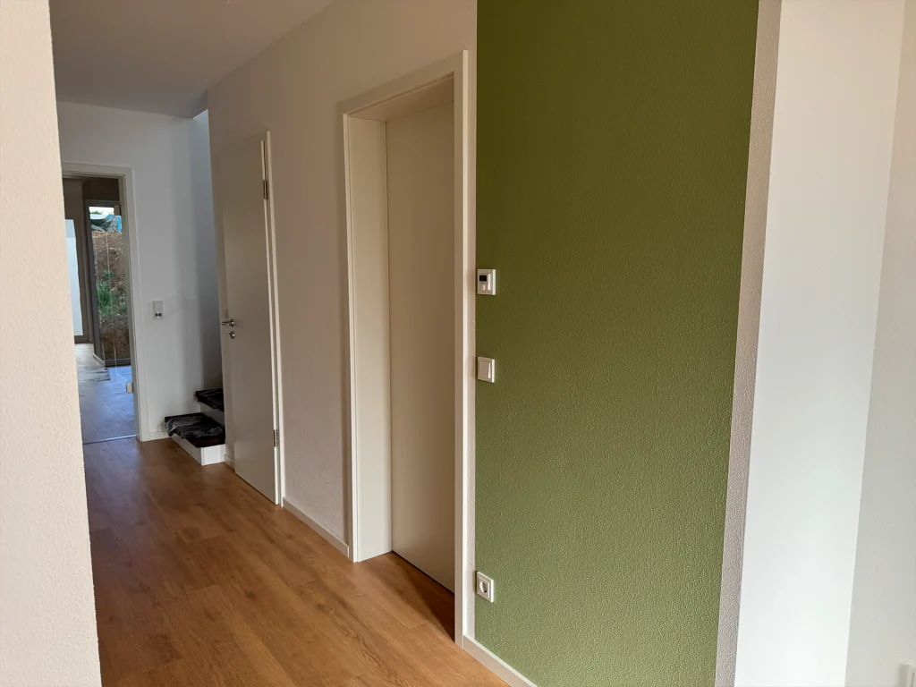 Freundlich gestalteter Flurbereich mit modernen Farbakzenten und klarer Linienführung.