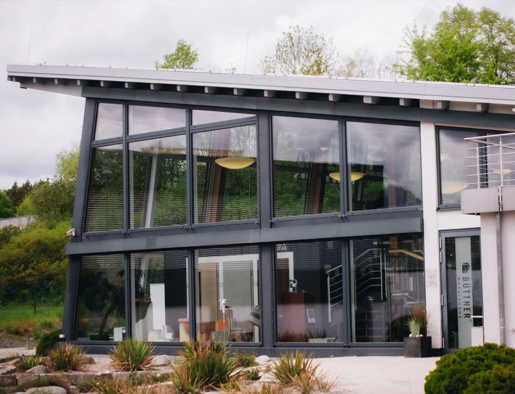 Modernes Büro- und Ausstellungsgebäude von Büttner Massivhaus mit großzügiger Glasfassade und zeitgemäßer Architektur.