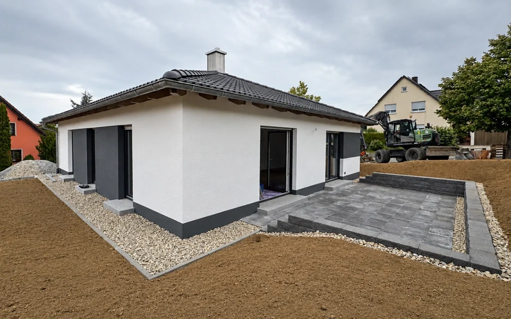 Moderner Walmdach-Bungalow mit Terrasse und großzügigem Gartenbereich.