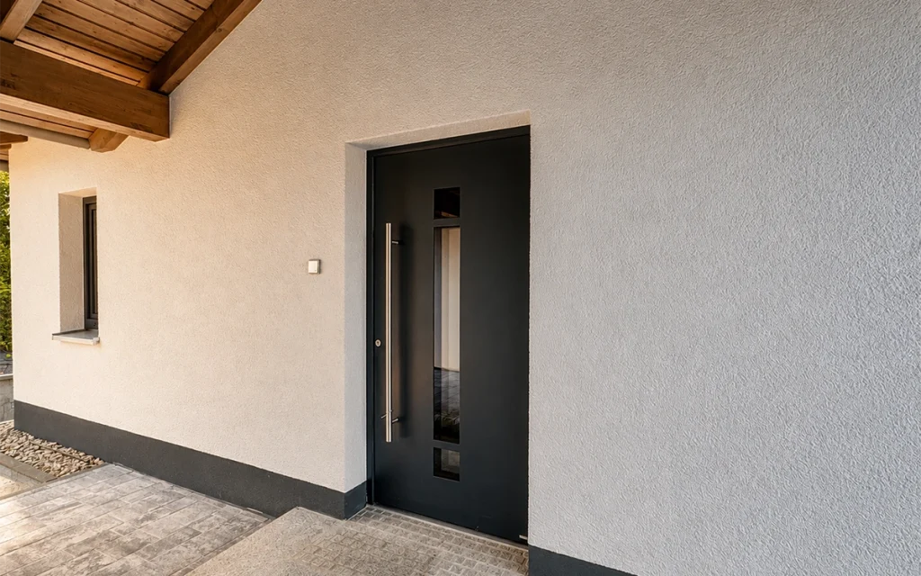 Überdachter Hauseingang mit moderner anthrazitfarbener Haustür und großzügigem Eingangsbereich.