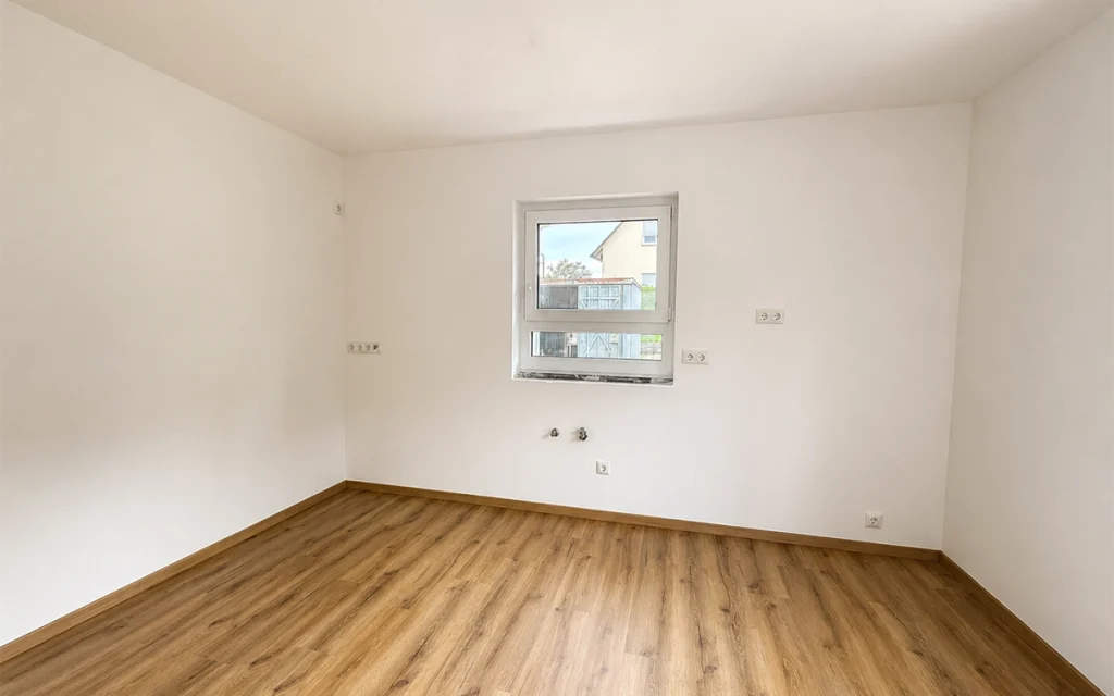 Offener Küchenbereich mit Fenster und Anschlüssen für die individuelle Küchengestaltung.