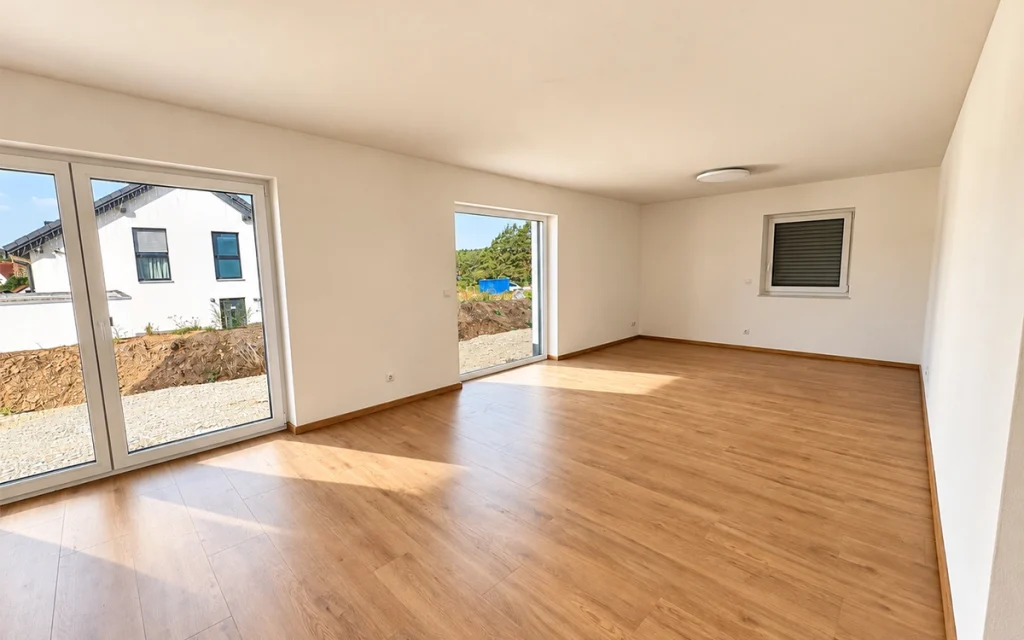 Helles Wohnzimmer mit großen Fenstern und Holzfußboden