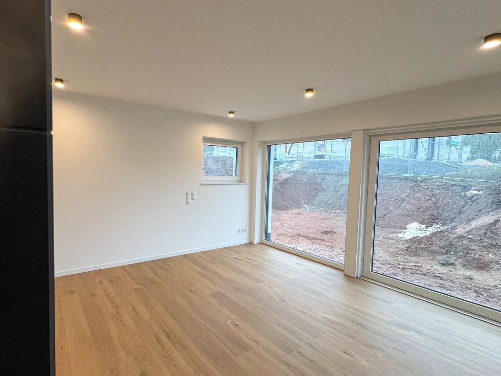 Offener Wohn-/Essbereich mit großen Fensterflächen und viel natürlichem Licht.